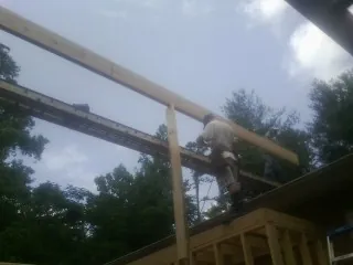 Carpenter setting a ridge beam over a new addition frame — Ice Dam Removal by Roofing Brothers in Wyoming